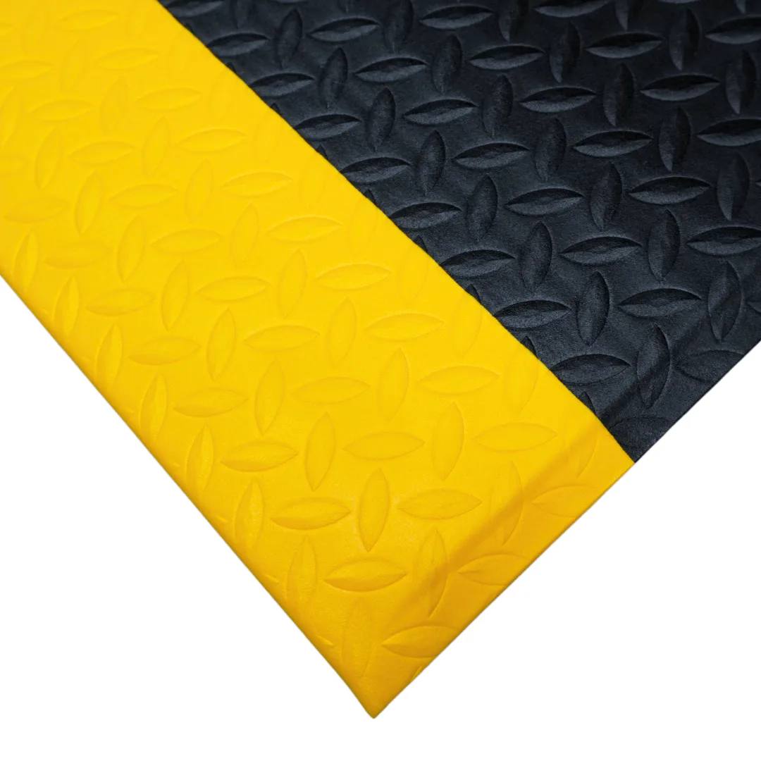 Corner of the M2 mat: black diamond-plate surface with a yellow safety border.